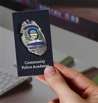 Community Police Academy Ohio State badge with a hand holding it
